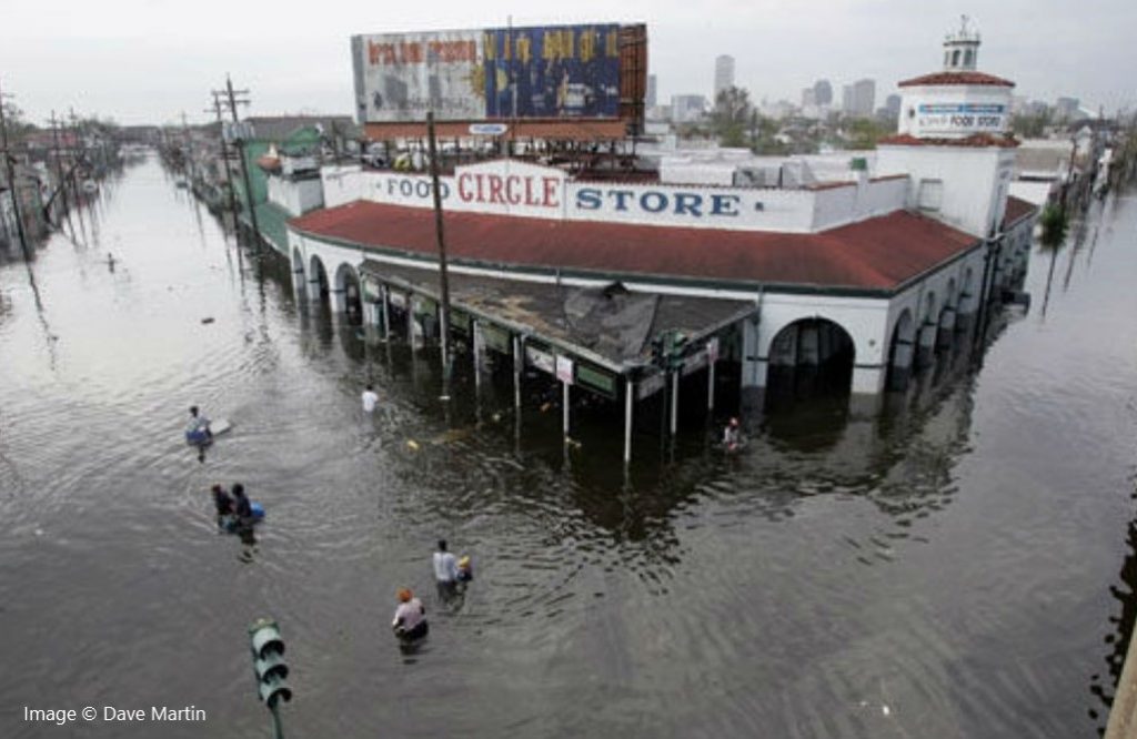Photo of looters making their way into a grocery store on a flooded street in New Orleans in 2005